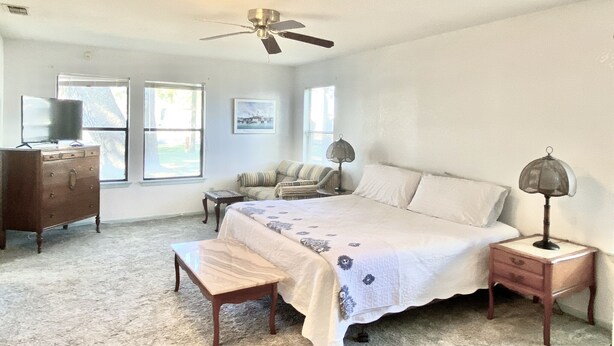 A bedroom with a bed, a dresser, a chair, a desk, and a ceiling fan. - Ranch Style House 1/2 Block from Fulton Park & Fishing Pier on Aransas Bay. (Fulton)