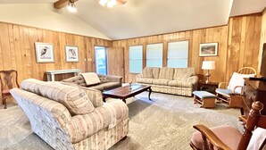A cozy living room with two sofas, a coffee table, and a wooden ceiling fan. - Ranch Style House 1/2 Block from Fulton Park & Fishing Pier on Aransas Bay. (Fulton)