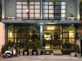 A modern building with large windows, a neon sign reading "Good Night," and potted plants outside.