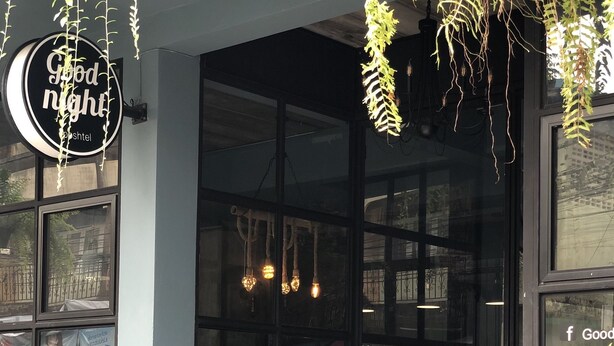 A modern building entrance with a glass door, a staircase leading up, and a sign that reads "Good night". - Goodnight Poshtel (Hat Yai)