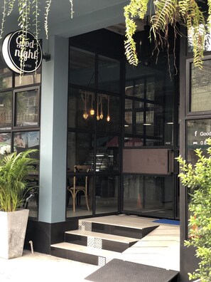 A modern building entrance with a glass door, a staircase leading up, and a sign that reads "Good night". - Goodnight Poshtel (Hat Yai)