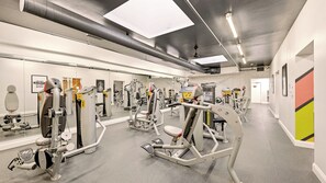 A gym with various exercise machines, mirrors, and a clean, modern design.