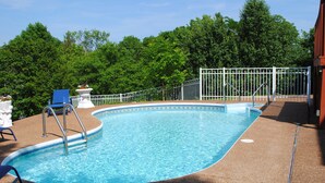 A swimming pool with a white fence, a blue chair, and a white statue. - Spacious, beautifully designed, spectacular views, awesome pool. (Nashville)