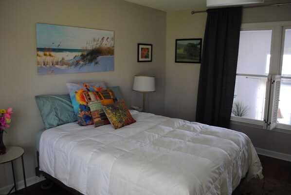 A bedroom with a large bed, a nightstand, a lamp, and a window with curtains. - Spacious, beautifully designed, spectacular views, awesome pool. (Nashville)