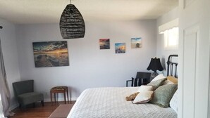 A bedroom with a large bed, a chair, a small table, and a hanging light fixture. - Spacious, beautifully designed, spectacular views, awesome pool. (Nashville)
