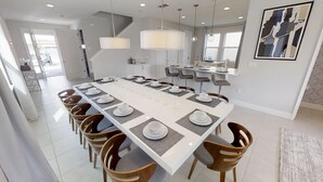Un espace de restauration moderne avec une longue table dressée pour un repas, entourée de chaises en bois.