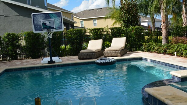 A swimming pool with lounge chairs and a basketball hoop. - Encore Resort at Reunion 1866 (Kissimmee)