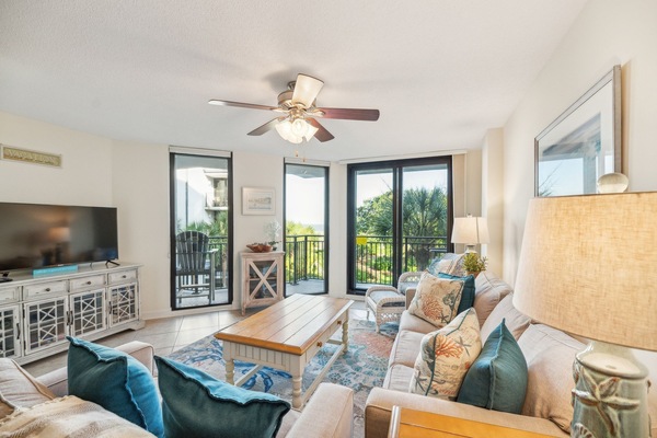 Sitting room with arm chair, full size sofa, double sofa, and smart TV.