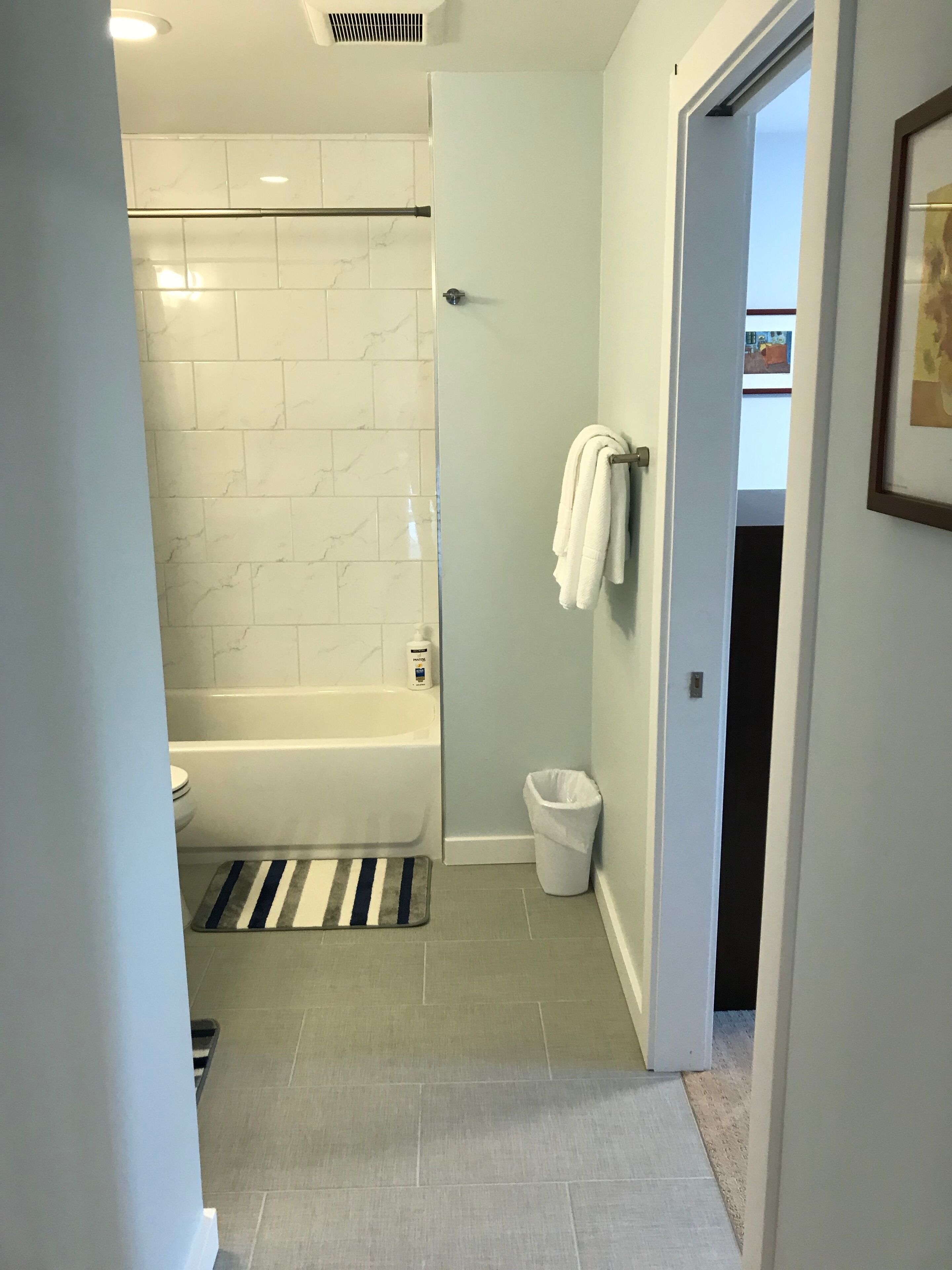 A modern bathroom with a bathtub, toilet, and a shower area.