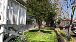 A well-maintained lawn with a wooden deck and a stone pathway. - The Caden Hotel (Vernonia)
