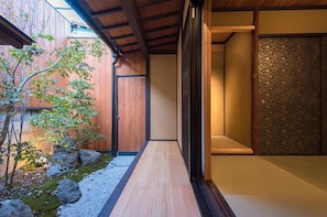 A traditional Japanese interior with a wooden floor, a tatami mat room, and a small garden area with rocks and a tree. - 5` to imperial palace & subway. Boutique (Kyōto-shi)
