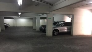 Eine mehrgeschossige Parkgarage mit Betonböden und -säulen, mit einem Schild, das einen Ausgang kennzeichnet.