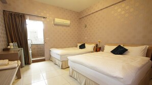 A hotel room with two beds, a bathroom, and a small desk with toiletries. - Hilarity B&B (Hualien City)