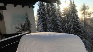 Ein mit Schnee bedecktes Auto vor einem Geb äude im traditionellen Baustil.