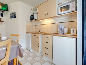 Kitchen area with microwave, coffee maker, toaster, refrigerator, dishwasher, sink, and dining table.