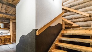 Eine Holztreppe mit Wand in Schwarzweiß, die zu einem Holzboden führt.