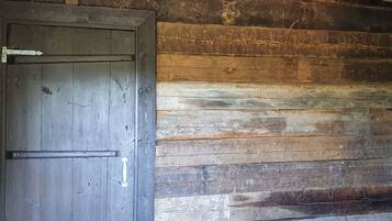 A rustic wooden door with a metal latch and a small window above it.