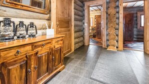 Ein Holzblockhaus-Interieur mit einem hölzernen Schmuckkästchen, einem Spiegel und drei Laternen.