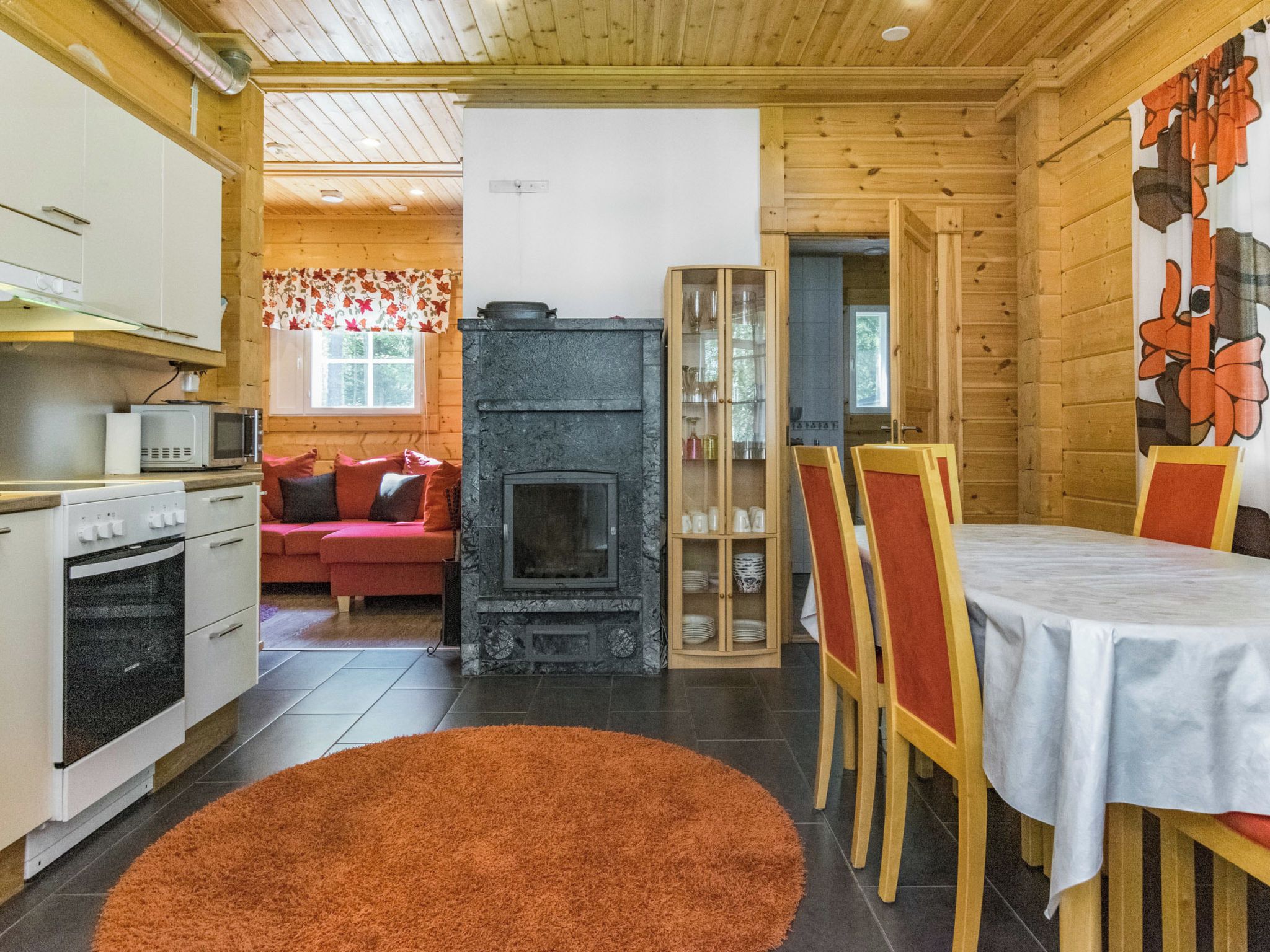 Ein gemütliches Blockhaus-Interieur mit einer Küche, einem Essbereich und einem Kamin.