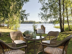 A lakeside outdoor seating area with wicker furniture and a view of the lake. - Joutsenlahti by Interhome (Asikkala)