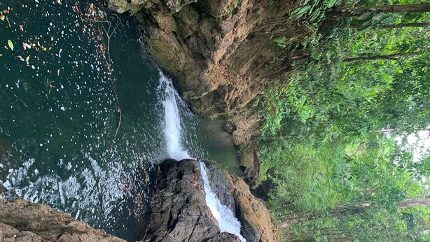A waterfall cascading through a rocky gorge surrounded by dense green foliage. - Paraisoverde -Corcovado (DrakeBay)