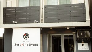 A multi-story hotel with balconies, a signboard for Rest Inn Kyoto, and a glass entrance. - Rest inn Kyoto (Kyoto)