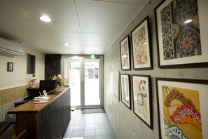 A reception area with a reception desk, framed artwork on the walls, and a tiled floor.