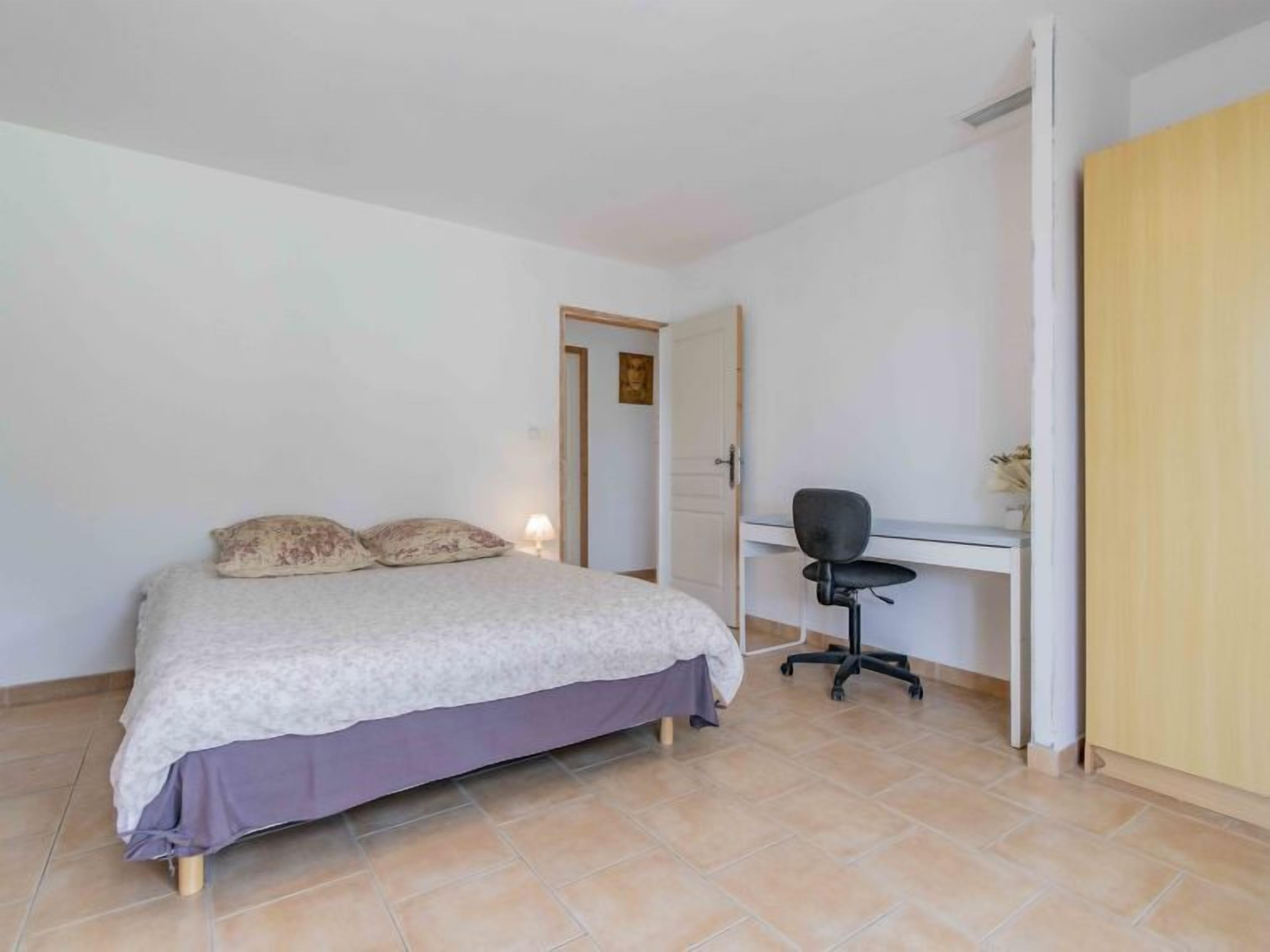 Une chambre à coucher avec un lit, un bureau et une chaise.