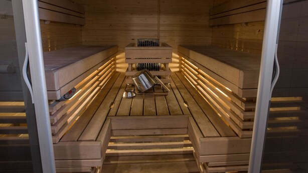 A sauna with wooden benches and a central heating element. - Pihkala 2 by Interhome (Äkäslompolo)