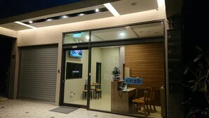 A modern building with a glass entrance, a closed garage door, and a sign indicating a room with a view.