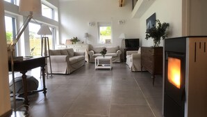 Una sala de estar amplia con chimenea, televisor y comedor.