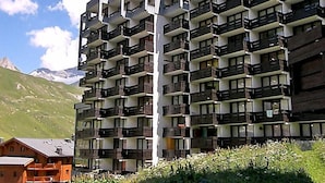 Un hôtel à plusieurs étages, doté de balcons, situé dans un cadre montagneux.