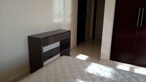 Ein Schlafzimmer mit einem Bett, einer dunklen Kommode und einem Kleiderschrank.