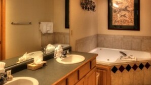 A bathroom with a double sink vanity, a bathtub, and a framed artwork on the wall. - Grand Timber One Bdr Master Full Kitchen Breckenridge, CO Ski-In/Out 5 Star (Breckenridge)