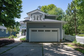 A two-story house with a garage, a covered porch, and a small deck.
