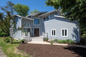 A two-story house with a front porch, a garage, and a landscaped front yard. - Bethany Beach Getaway (Bethany Beach)