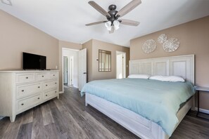 A bedroom with a bed, dresser, ceiling fan, and decorative wall art. - Bethany Beach Getaway (Bethany Beach)