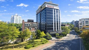 A Renaissance Hotel with a modern design, surrounded by greenery and a clear sky.