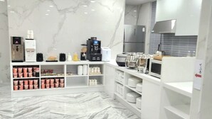 A modern kitchen with marble flooring, built-in appliances, and a central island.