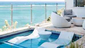 A pool area with a view of the ocean, white outdoor furniture, and a modern architectural design. - Añoranza 3 BDRM: 2 Bedroom Villa + Casita 2 (Punta Blanca)