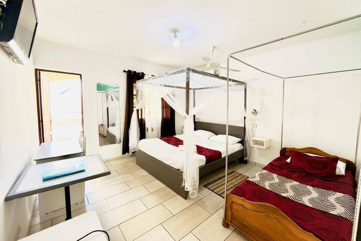 Un dormitorio con cama con dosel, un escritorio y una silla.