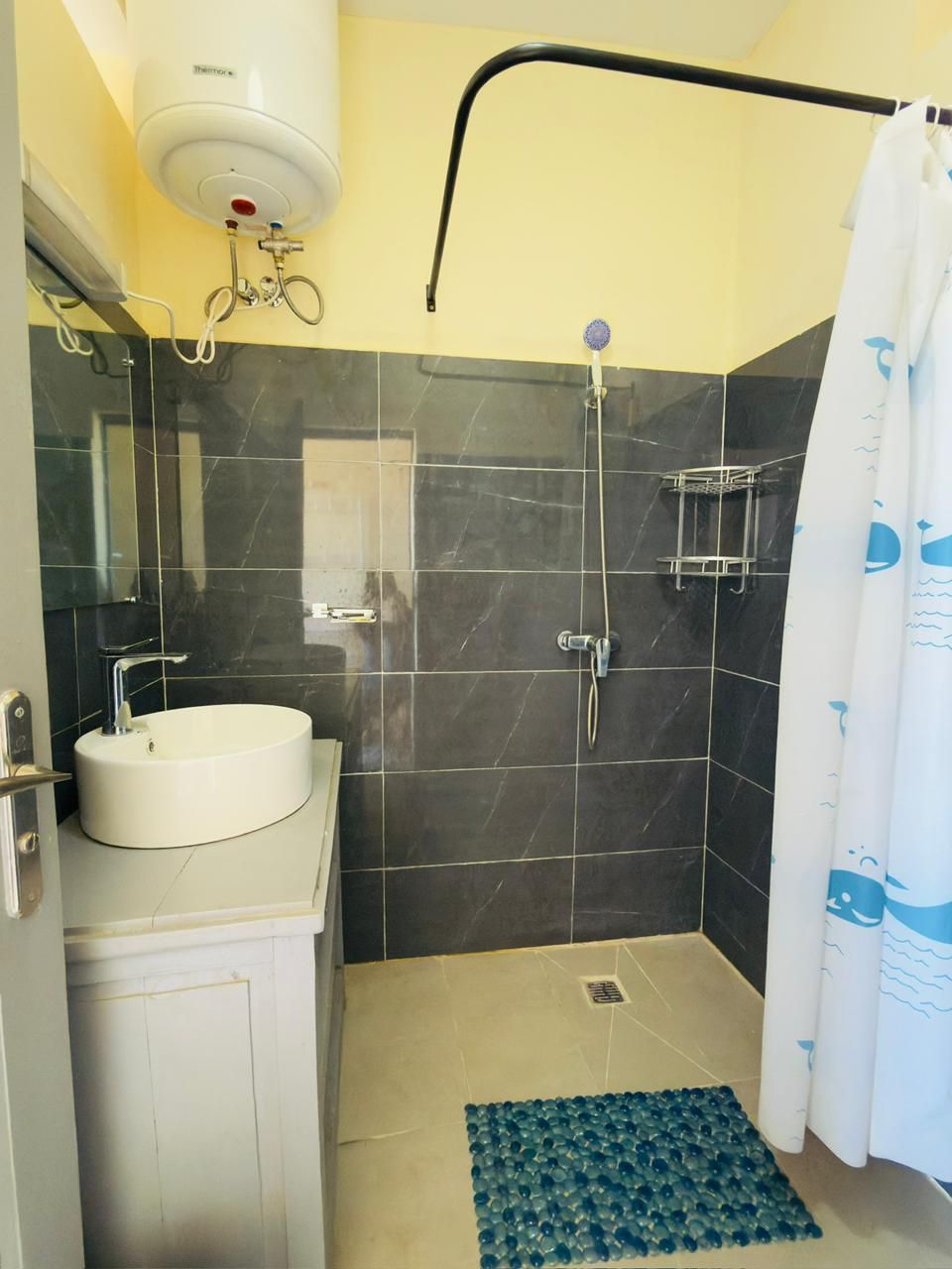 Un baño con lavamanos blanco, ducha e inodoro.