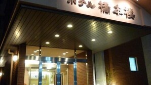 A hotel entrance with a curved sign displaying the name in Japanese characters. - Hotel Hashimotorou (Ishioka)