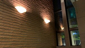 A corner of a room with a brick wall and a window. - Hotel Hashimotorou (Ishioka)