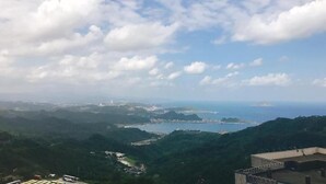 A coastal landscape with a view of the sea and distant cityscape. - J.F Sleepless Ones Garden Hotel (New Taipei City)