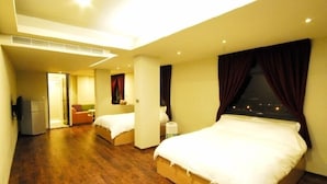 A hotel room with two beds, a small kitchenette, and a view of the city at night. - J.F Sleepless Ones Garden Hotel (New Taipei City)