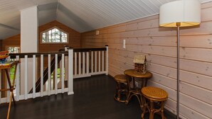 A wooden interior with a staircase, a small table with chairs, and a lamp. - Villa raita by Interhome (Rääkkylä)