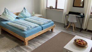 A bedroom with a bed, a desk, and a chair. - Nice central apartment with S-Bahn connection to Heidelberg and castle view (Hirschhorn (Neckar))