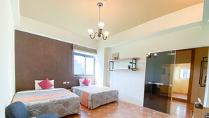 A hotel room with two beds, a chandelier, a window with curtains, a small shelf with a plant, and a sliding glass door leading to a hallway. - Time B&B (Hengchun)
