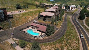 Um hotel com piscina, vários edifícios e uma estrada sinuosa.